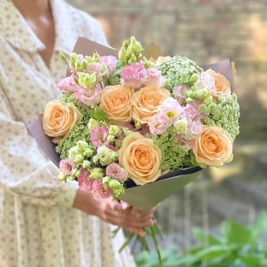 Romantic flower bouquet of peach roses, eustomas and greenery