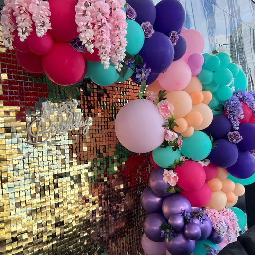 Гирлянда из шаров с блестящей стеной и цветами украшает