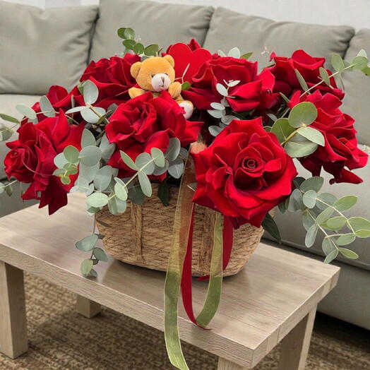 A basket with red roses, a bear, and a heart