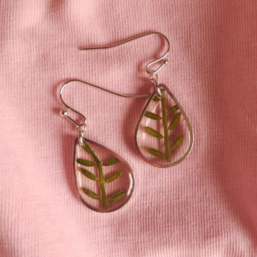 Tear drop shaped earrings with a real flowers
