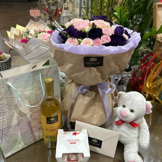 An attractive bouquet with candies, plush honey and wine