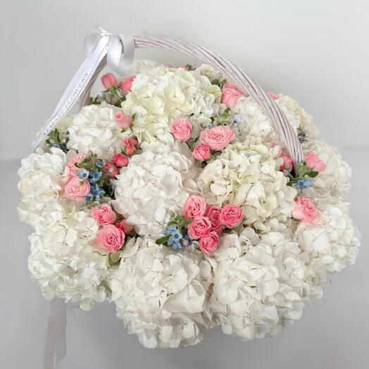 White hydrangeas with spray roses in a basket