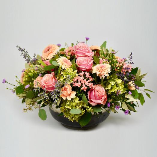 A generous, classic arrangement of flowers and green foliage in a meta
