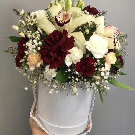 Boîte de fleurs avec des orchidées et un œillet