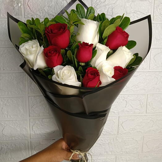 Ramo de rosas blancas y rosas rojas envueltas en papel floral