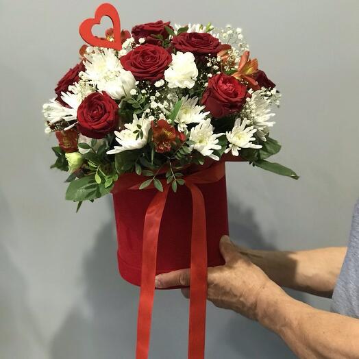 Roses rouges avec une marguerite dans une boîte