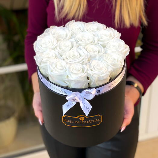 Roses éternelles blanches dans une boîte ronde noire